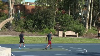 People playing basketball at a park in Chula Vista even though it's not allowed.