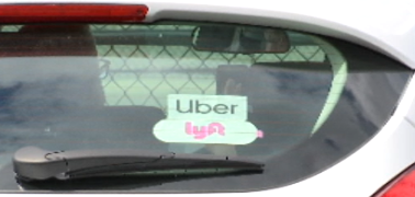 Uber and Lyft stickers on a car