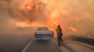 A firefighter battles flames.