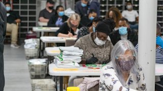 Gwinnett County election workers handle ballots as part of the recount for the 2020 presidential election at the Beauty P. Baldwin Voter Registrations and Elections Building on November 16, 2020 in Lawrenceville, Georgia.