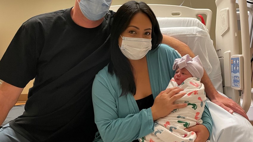 Nick and Melissa Hawke with their newborn, Delmar.