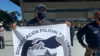 oficial sostiene escudo de la organización policial