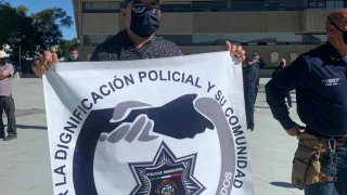 oficial sostiene escudo de la organización policial