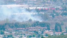 Smoke can be seen from a brush fire in Santee on Friday, Feb. 26, 2021.