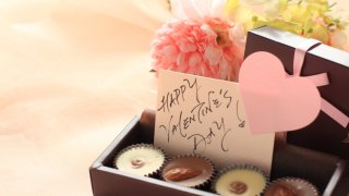 A card reading "Happy Valentine's Day" next to flowers and chocolates.