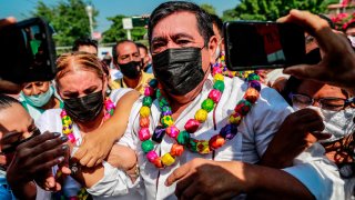Polémico candidato mexicano luce collares de colores en un acto de campaña