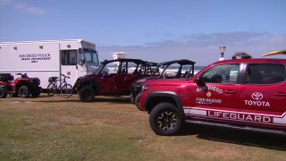 Beach safety vehicles from San Diego police and lifeguards stationed at Mission Beach.