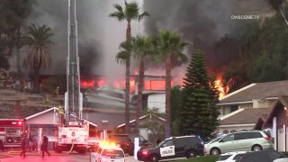 Firefighters respond to the scene of a blaze at two homes in El Cajon on Friday, May 14, 2021.