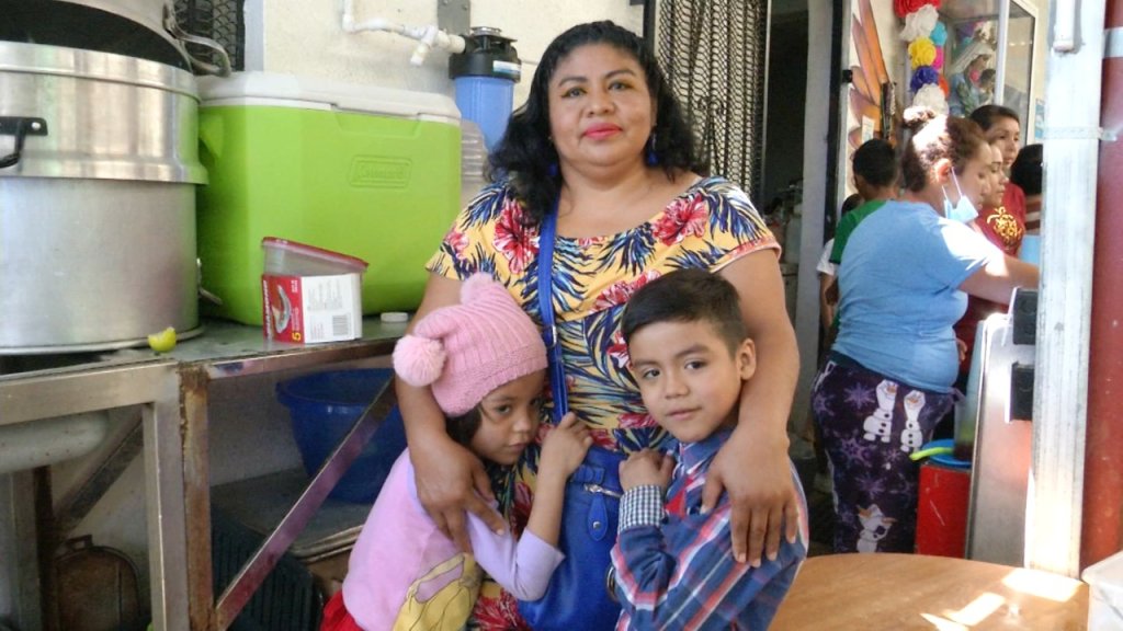 Madre migrante con sus dos hijos en un albergue en Tijuana