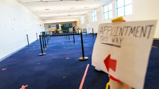 A sign points the way to a check-in area at a coronavirus mass-vaccination site at the former Citizens Bank headquarters in Cranston, R.I., Thursday, June 10, 2021. The U.S. is confronted with an ever-growing surplus of COVID-19 vaccines, looming expiration dates and stubbornly lagging demand at a time when the developing world is clamoring for doses to stem a rise in infections.