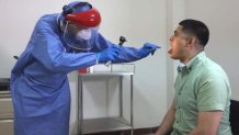 Un médico realiza una prueba a un posible enfermo de COVID-19
