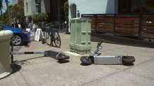 Scooters on ground on sidewalk in Little Italy