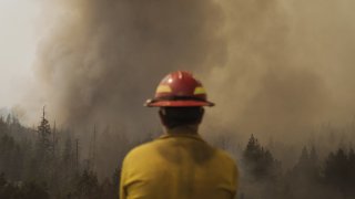 A firefighter watches fire burning through trees during the Caldor Fire in Kirkwood, California, U.S., on Friday, Sept. 3, 2021. The Caldor Fire, which ignited Aug. 14 has burned at least 212,907 acres, or more than 332 square miles, and containment stood at 29% as of Friday, Cal Fire said in its morning update. Photographer: Eric Thayer/Bloomberg via Getty Images
