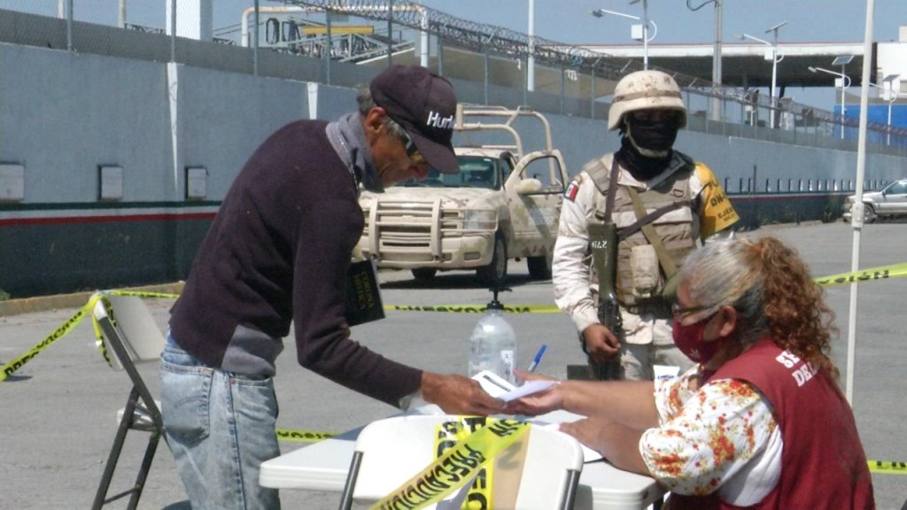persona llena formulario mientras vigila un militar