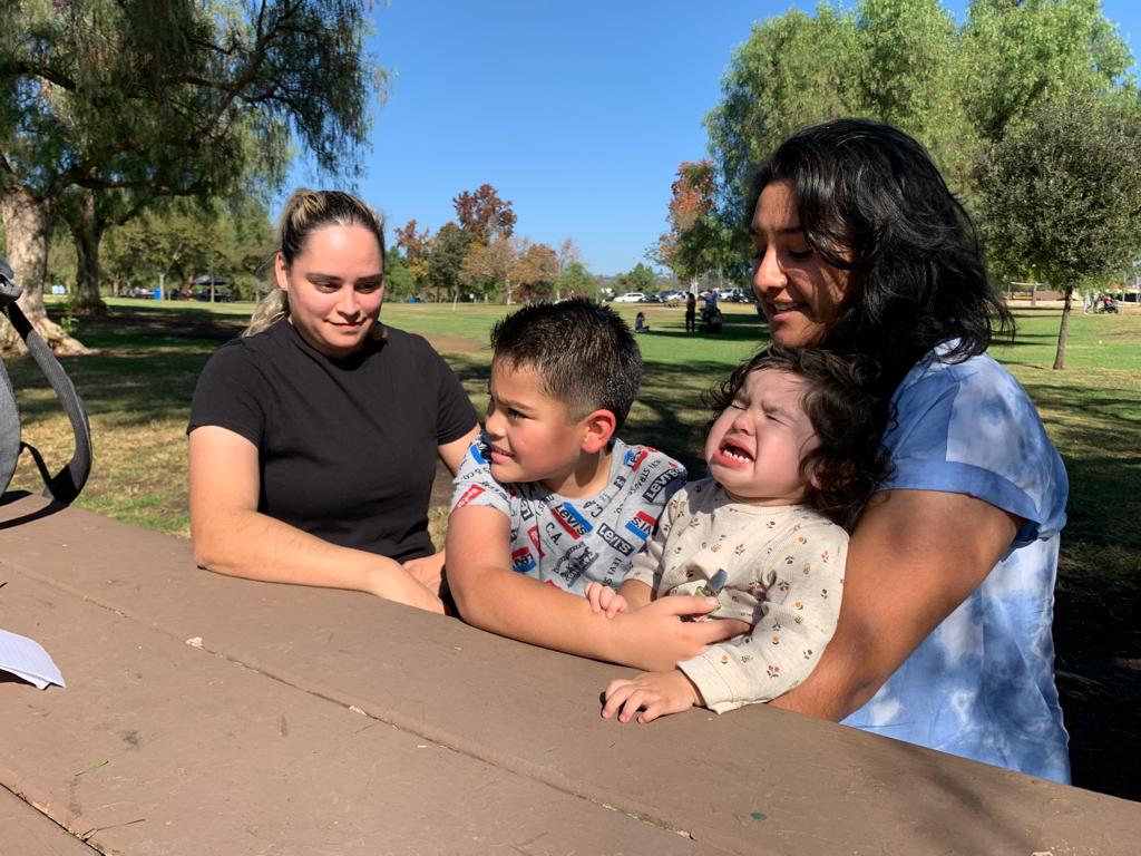 Dos madres con sus hijos en un mesa de un parque