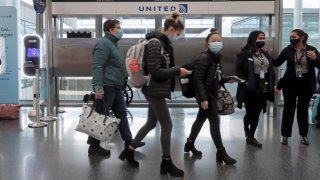 grupo de pasajeros con mascarilla en un aeropuertoi