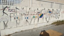 Posters de colores cubren graffiti con frases inspiracionales