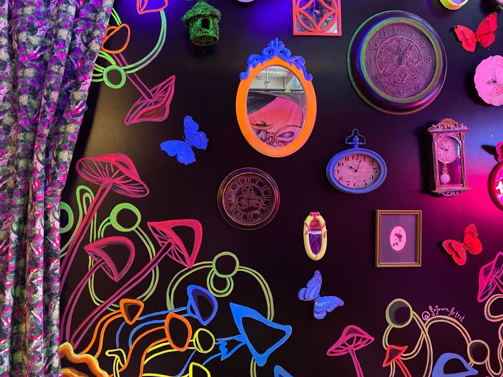 Falling down the rabbit hole includes an array of clocks, mirrors and brilliantly neon colors.