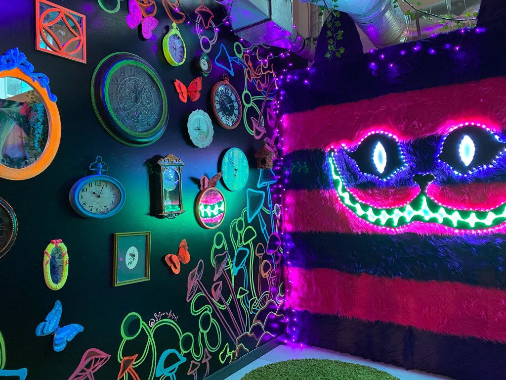A mischievous smile from the iconic cheshire cat overlooks this portion of The Alice - An Immersive Cocktail Experience pop-up.