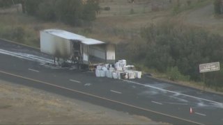 A semi-trailer rests on the side of Interstate 8 in Alpine on Wednesday, May 25, 2022 following a fire.