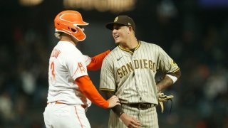 Base runner Joc Pederson #23 of the San Francisco Giants talks with third baseman Manny Machado #13 of the San Diego Padres in the bottom of the eighth inning at Oracle Park on August 30, 2022 in San Francisco, California.