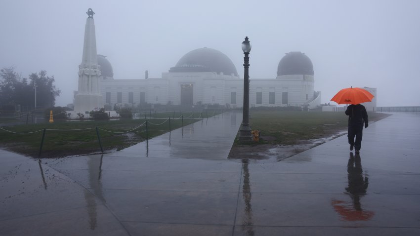 LOS ANGELES, CALIFORNIA – FEBRUARY 24: A person walks in the rain at Griffith Observatory on February 24, 2023 in Los Angeles, California. A major storm, carrying a rare blizzard warning for parts of Southern California, has begun to deliver heavy snowfall to the mountains with some snowfall expected to reach lower elevations in Los Angeles County. (Photo by Mario Tama/Getty Images)