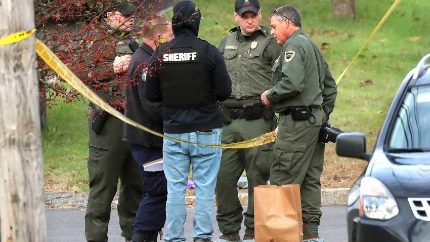 Lewiston, ME – October 26: Police stand by the scene with an evidence bag in the parking lot of Schemengees Bar and Grille which was the scene of a mass shooting the night prior.