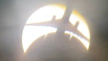 A plane crosses the path of the eclipse.