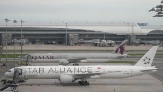 El avión Boeing 777-300ER de Singapore Airlines, al frente, está estacionado después del vuelo SQ321 Londres-Singapur, que encontró severas turbulencias, en el Aeropuerto Internacional de Suvarnabhumi, cerca de Bangkok, Tailandia, el 22 de mayo de 2024.