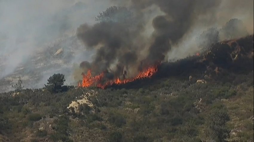 Footage from SkyRanger7 showed a fire burning around Del Mar Heights Road coming close to homes near Mira Montana Drive on June 25, 2024. (NBC 7 San Diego)
