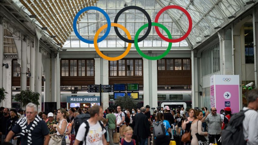 Commuters walk under the Olympic rings at the Gare de Lyon train station, on July 21, 2024, ahead of the Paris 2024 Olympic and Paralympic Games. (Photo by Loic VENANCE / AFP) (Photo by LOIC VENANCE/AFP via Getty Images)