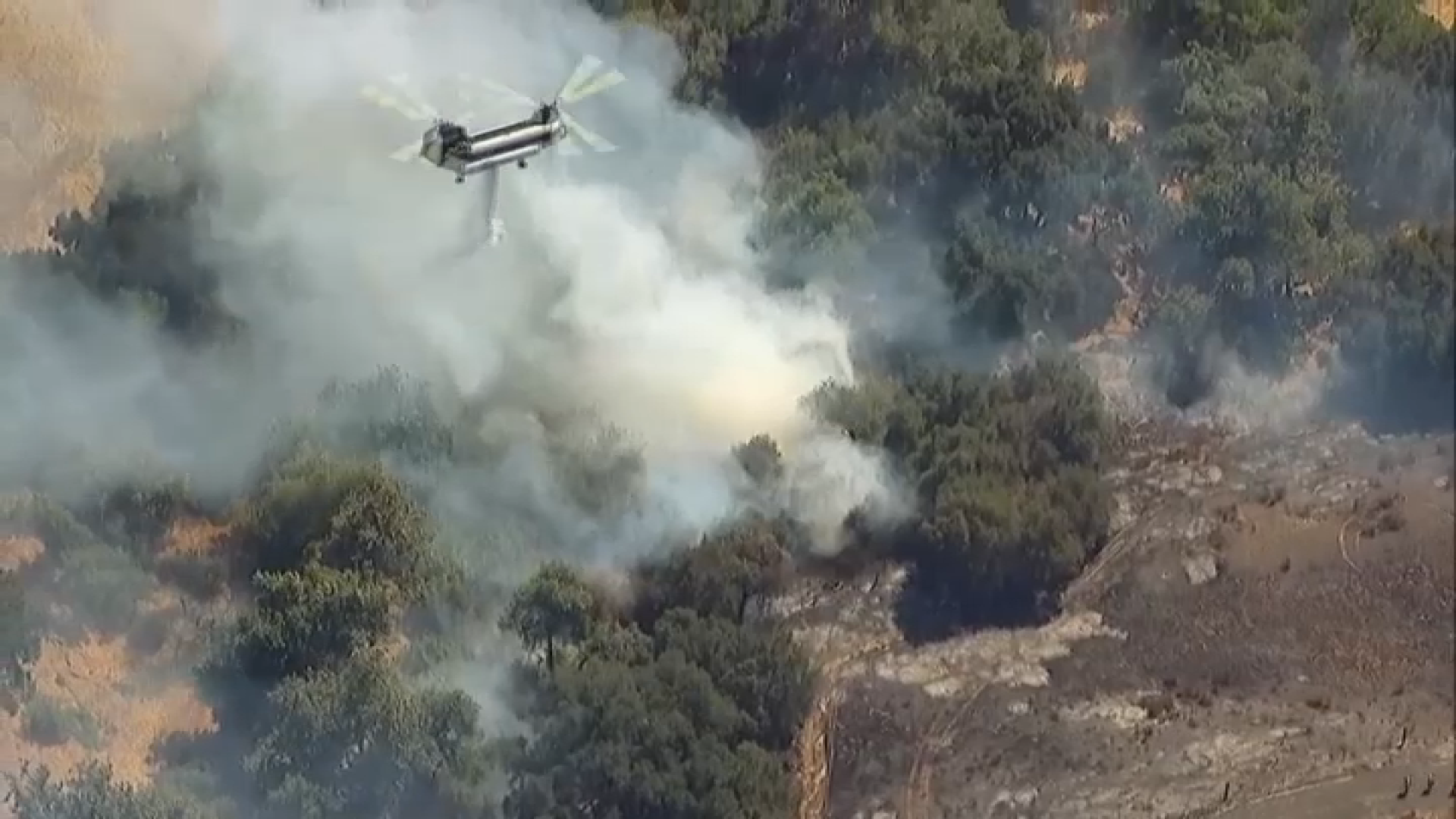 Fire crews work to drop water on a brush fire that broke out in Valley Center, Aug. 28, 2024.