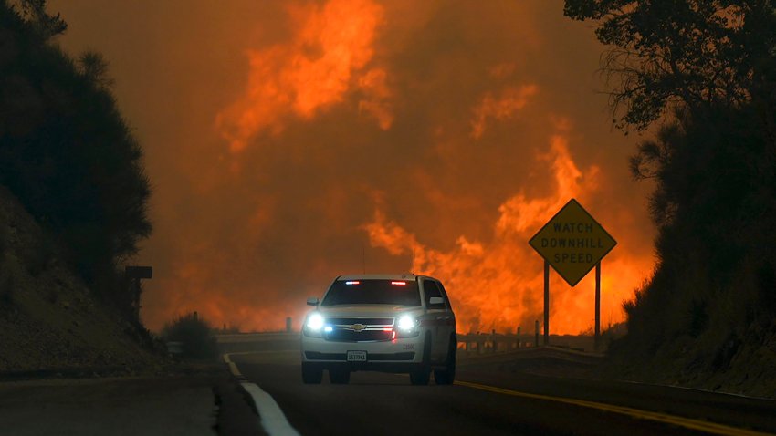 ARCHIVO – El incendio Line arde sobre la autopista 330 mientras un vehículo de emergencia pasa frente a él, el sábado 7 de septiembre de 2024, cerca de Running Springs, California. (AP Foto/Eric Thayer, Archivo)