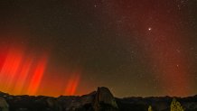 The northern lights, also known as the aurora borealis, glows over Half Dome in Yosemite National Park, Calif., on Friday, Oct. 11, 2024. (Photo by Carlos Avila Gonzalez/San Francisco Chronicle via Getty Images)