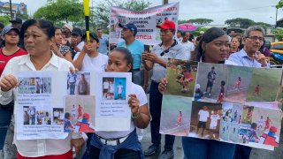 Familiares de los cuatro menores ecuatorianos desaparecidos sostienen carteles durante un plantÛn en los exteriores de la FiscalÌa de Guayaquil este martes, en Guayaquil.