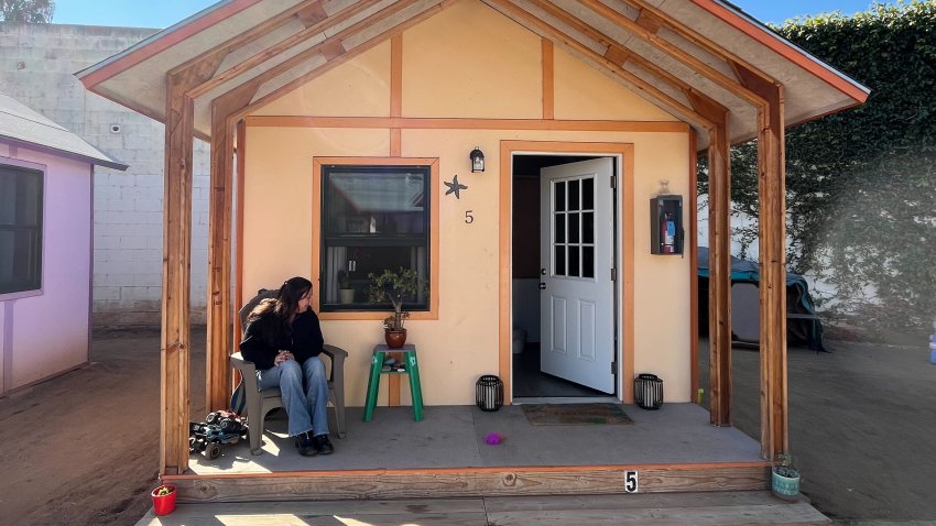 Carol Ortiz sits outside one of El Cajon's tiny homes.