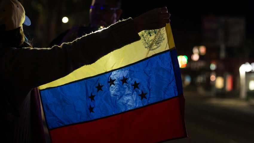 Una mujer venezolana sostiene una bandera de Venezuela mientras participa en una manifestación pública de apoyo a Juan Guaido el 24 de enero de 2018 en Mexicali, México.