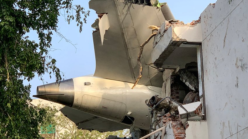 The back of Air India flight 171 is pictured at the site after it crashed in a residential area near the airport in Ahmedabad on June 12, 2025. A London-bound enger plane crashed in the Indian city of Ahmedabad on June 12 and all 242 people on board were believed killed, with the jet smashing into buildings housing doctors and their families. (Photo by Sam PANTHAKY / AFP) (Photo by SAM PANTHAKY/AFP via Getty Images)