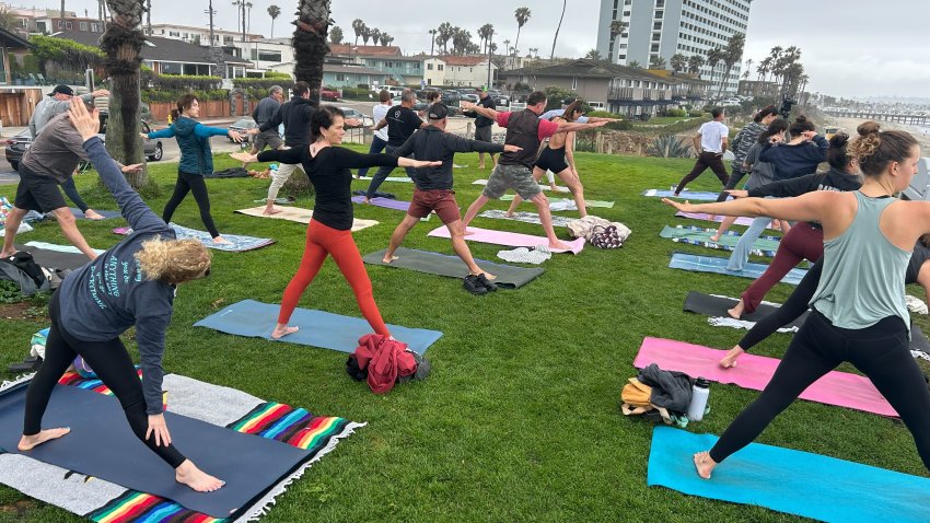 Yogis practice their warrior pose at Palisades Park in Pacific Beach, June 5, 2025.