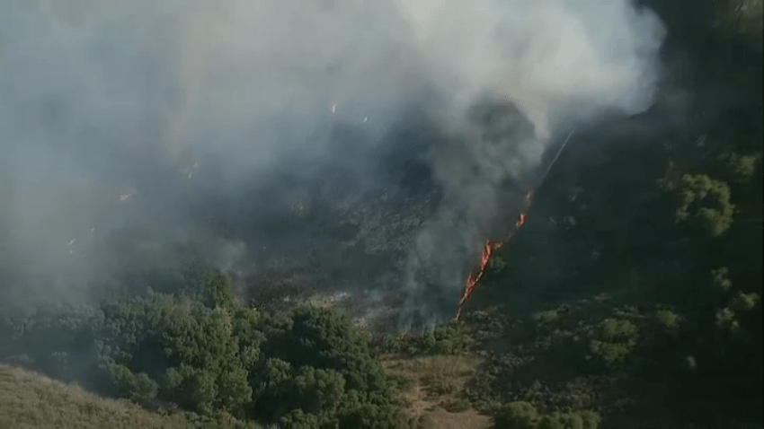 A fire burns in Tecolote Canyon on June 24, 2025.
