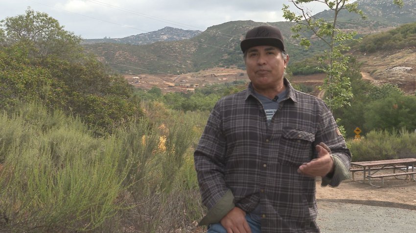 Man stands in front of a green valley.